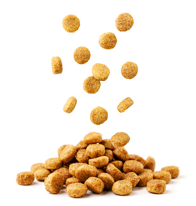 Pet food falls on a pile close-up on a white background. Isolated