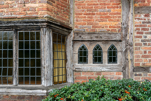 Detail of an ancient wooden window on an historic brick building