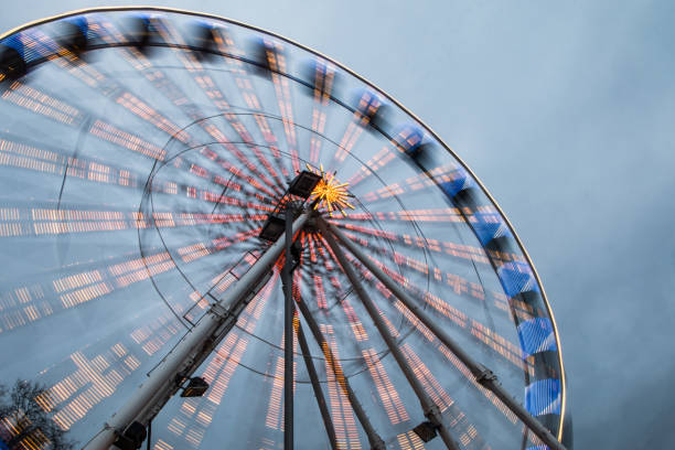 un dettaglio della ruota panoramica in movimento con luci accese. - ferris wheel wheel blurred motion amusement park foto e immagini stock