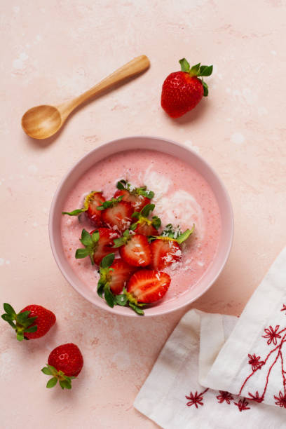 istock Breakfast with granola, coconut and strawberry smoothie in a bowl on a pink light background. Spring diet menu.Top view. 1297272950