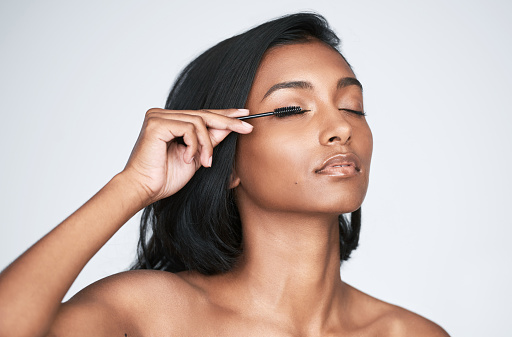Eyes, vision and beauty with contact lenses and black woman, eye care and cosmetics with closeup on studio background. Microblading, eyebrow and lashes, face and hand in portrait with manicure