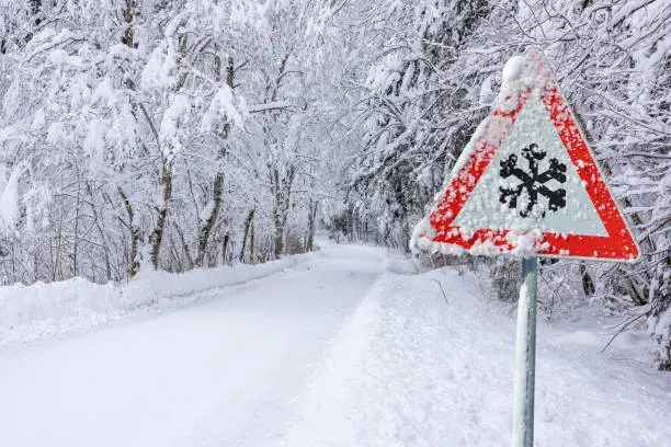 Photo of road sign warns of ice and snow at winter