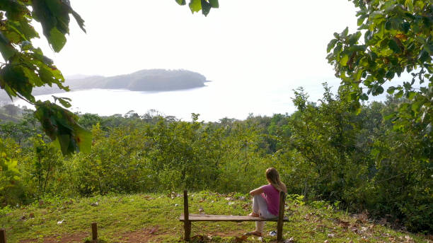 istock Young woman relaxes at coastal viewpoint in the morning 1297277558