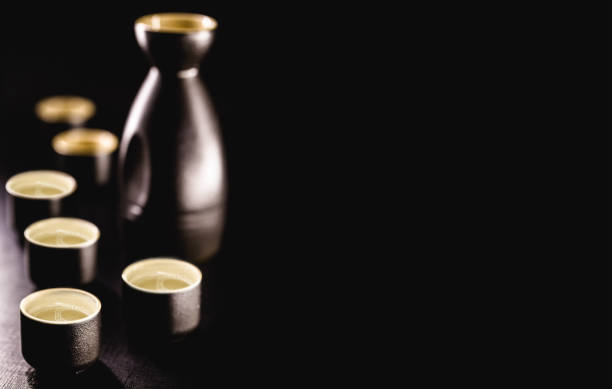 Sake, a traditional distilled and fermented alcoholic drink from Japan, served hot, produced from rice, water and kji. Black background with copy space