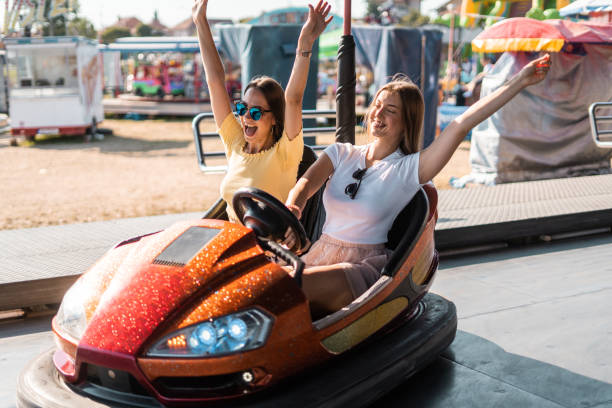 istock Two women having fun in electric bumper car in amusement park 1297278319