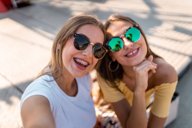 istock Two young women spending time in amusement park and taking selfie 1297278378