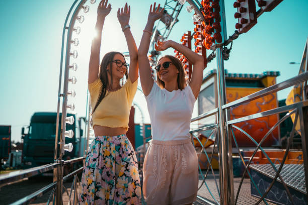 istock Two young cheerful women spending time and having fun in amusement park 1297278473