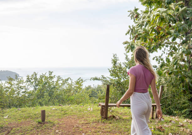 istock Young woman walks towards coastal viewpoint in the morning 1297278532