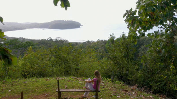 istock Young woman relaxes at coastal viewpoint in the morning 1297278534