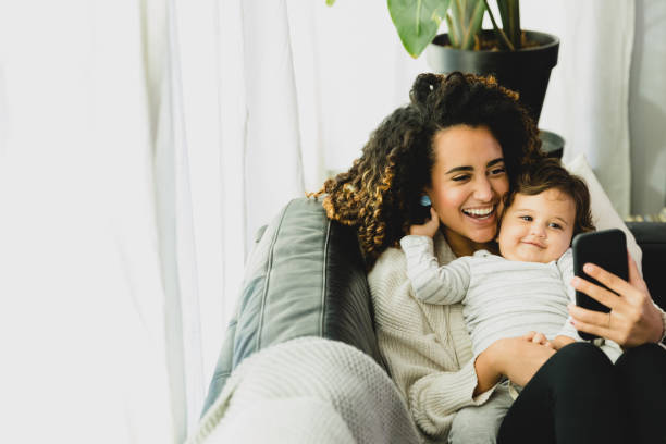 istock Mom and baby lying on sofa smile for selfie 1297281392