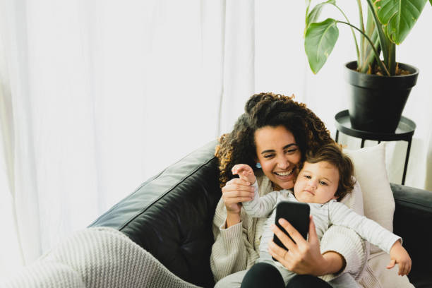 istock Happy woman video chats while holding young son 1297281480