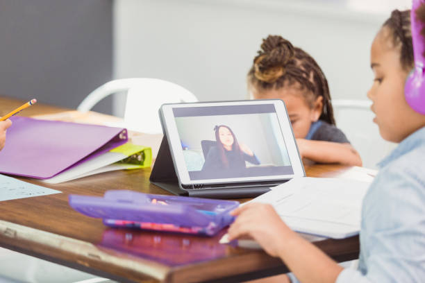 istock Schoolgirl chats with friend virtually during pandemic 1297281529
