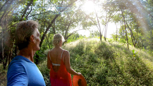 coppia matura cammina attraverso la foresta pluviale tropicale al mattino - tree harmony couple trust foto e immagini stock