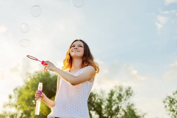 happy cheerful smiling girl teenager 15, 16 years old with soap bubbles - years 13 14 years teenager old imagens e fotografias de stock