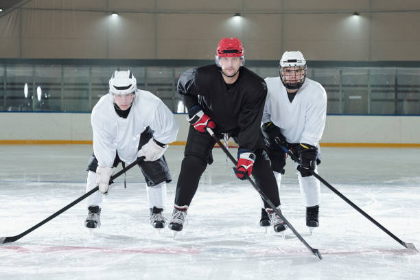 istock Three professional hockey players standing on rink during training before play 1297286014