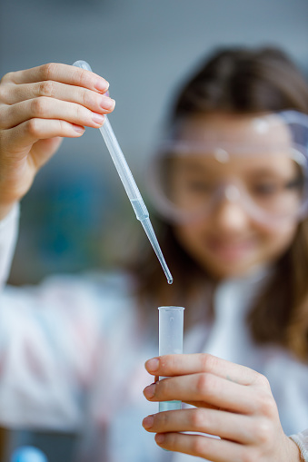 Close-up of young girl adding liquid in test tube