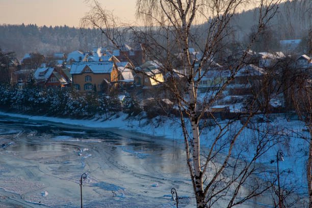 istock Frozen river, village covered with snow on the shore. 1297287132