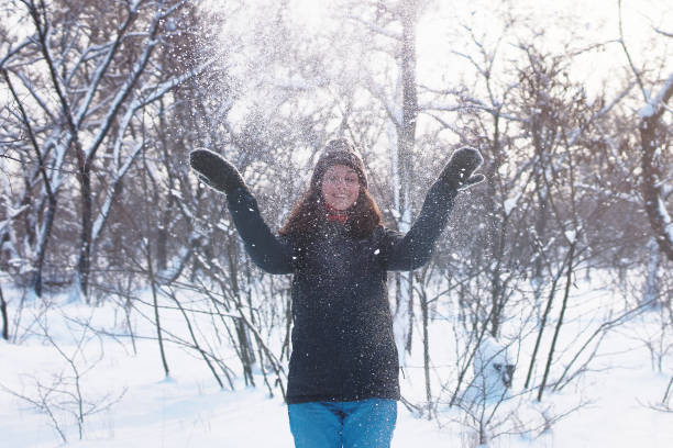 istock Beautiful woman having fun in snowy forest. 1297287215