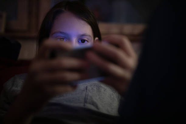 istock Young boy playing games on phone at night 1297290768