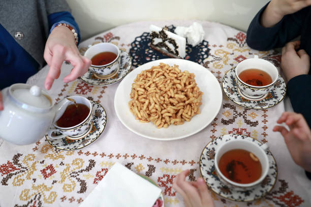 People eating chak-chak dessert with tea in tatar cafe