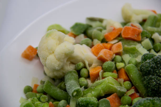 istock Frozen vegetables: cauliflower, green peas, leeks, broccoli, carrots, green beans on a white plate. 1297293250