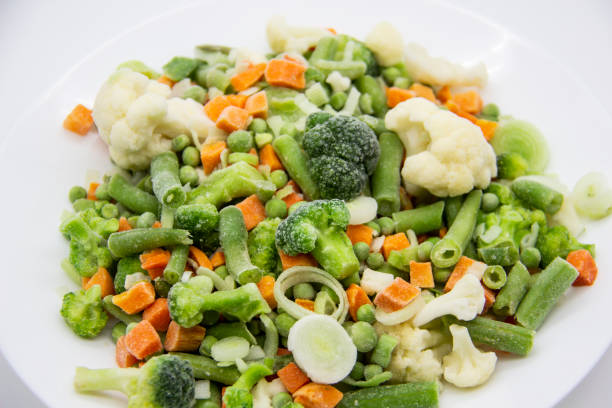 istock Frozen vegetables: cauliflower, green peas, leeks, broccoli, carrots, green beans on a white plate. 1297293256