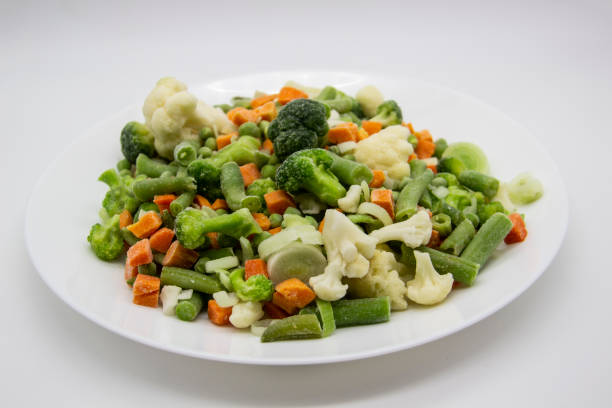istock Frozen vegetables: cauliflower, green peas, leeks, broccoli, carrots, green beans on a white plate. 1297293257