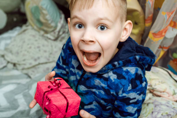 istock Child, boy emotionally holding a gift in his hands. 1297293676