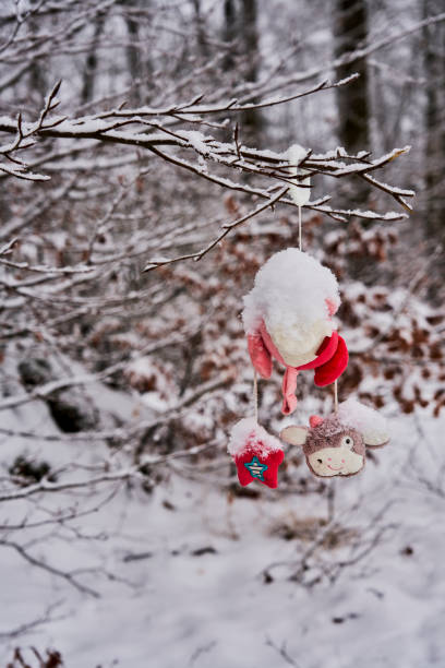 istock Snow-covered lost baby toys from a stroller hangs in the bush 1297295152