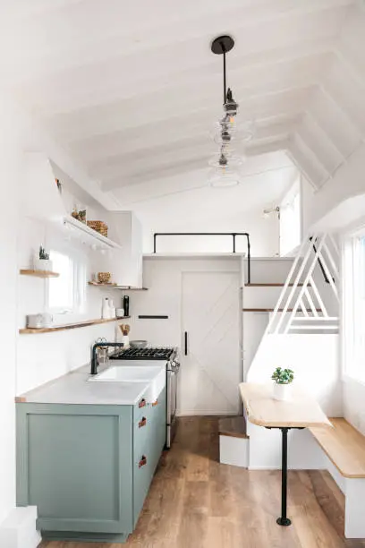 Interior Decor shot of Tiny House on a trailer, featuring a small space kitchen, bedroom, and bathroom.