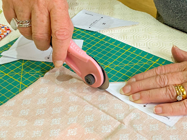 istock Person cutting fabric with a roller cutter 1297296137