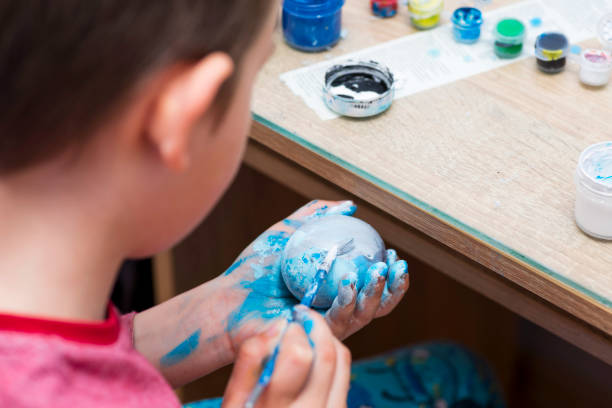istock Happy easter! A boy painting Easter eggs at home. A child preparing the easter eggs for Easter. 1297296156