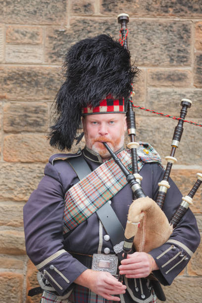 Portrait of a Bagpiper A Scottish bagpiper performs along the Royal Mile in Edinburgh Old Town during the Fringe Festival. glengarry cap stock pictures, royalty-free photos & images