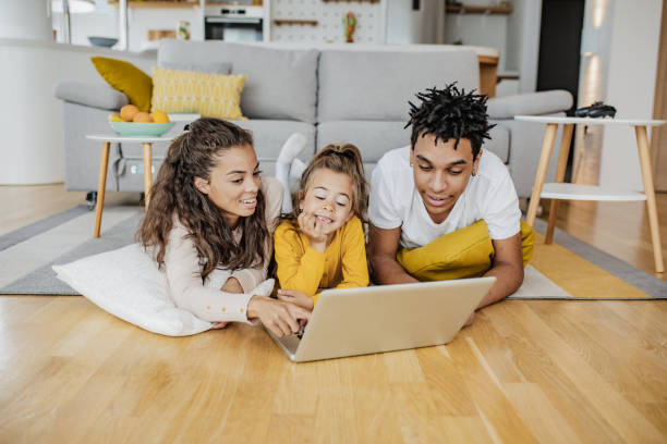 istock Parents and their daughter are using laptop at home 1297297904
