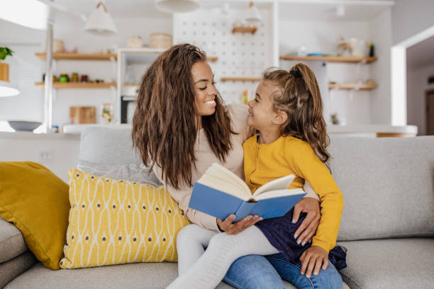 istock Mother is reading a book to her daughter at home 1297298536
