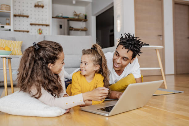 istock Parents and their daughter are using laptop at home 1297298618