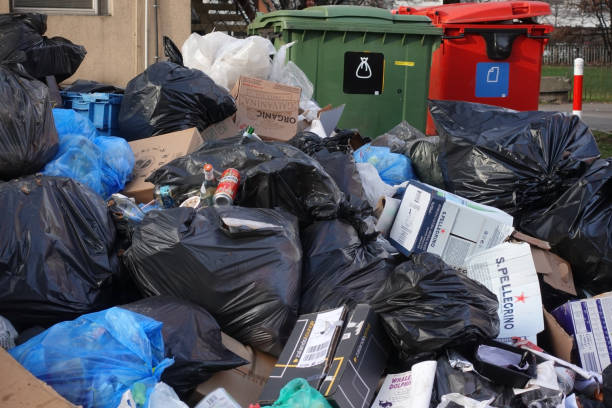 Garbage pile on a street Warsaw, Poland - 7th January, 2018: Garbage pile and overflowing rubbish containers on the street. overflowing trash dumpster stock pictures, royalty-free photos & images