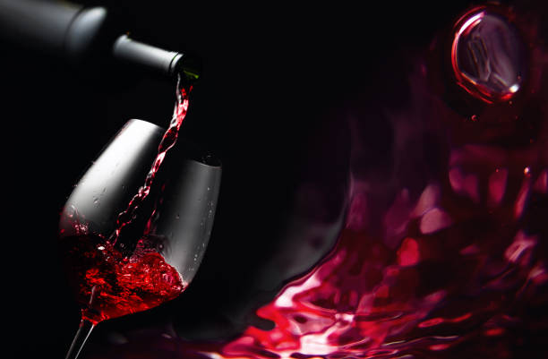 istock Pouring red wine in a glass goblet. 1297302462