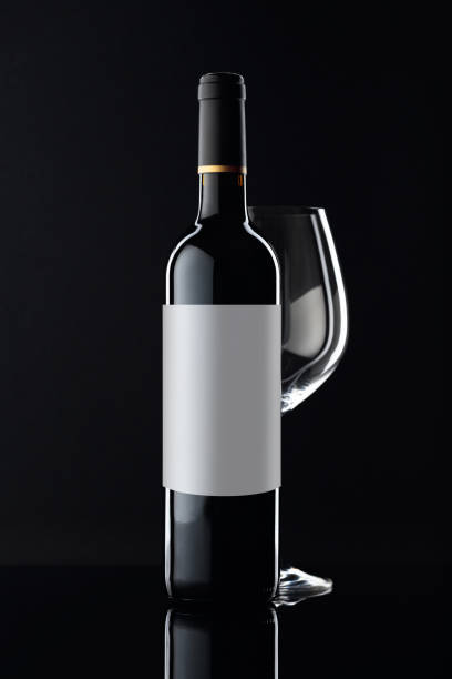 istock Bottle of red wine and empty glass on a black background. 1297302471