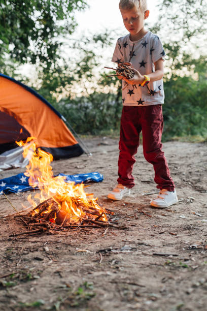 istock Boy Camping And Burning A Wood Fire 1297302976