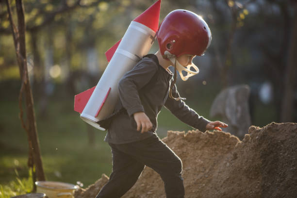 istock Cute boy in astronaut costume playing in back yard 1297303826