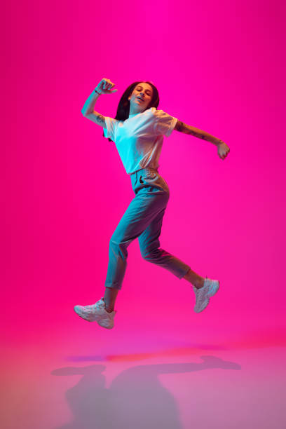istock Caucasian beautiful woman's portrait isolated on pink studio background in multicolored neon light 1297303862