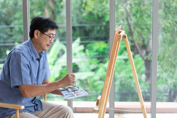 istock senior asian man painting at home 1297304061