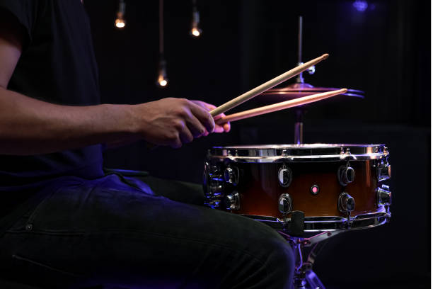istock Drummer playing snare drum with sticks close up. 1297304102