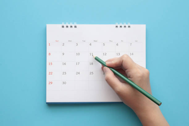 istock Hand with pencil mark on calendar date 1297304849