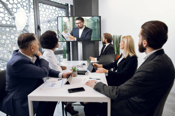 istock Team of five focused multiethnical businesspeople looking at screen, having video conference in modern office, with their male colleague explaining some financial charts. Telemeeting 1297306653