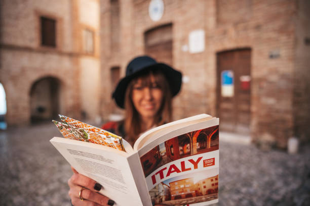 turista donna visita una piccola città per le vacanze - guidebook foto e immagini stock