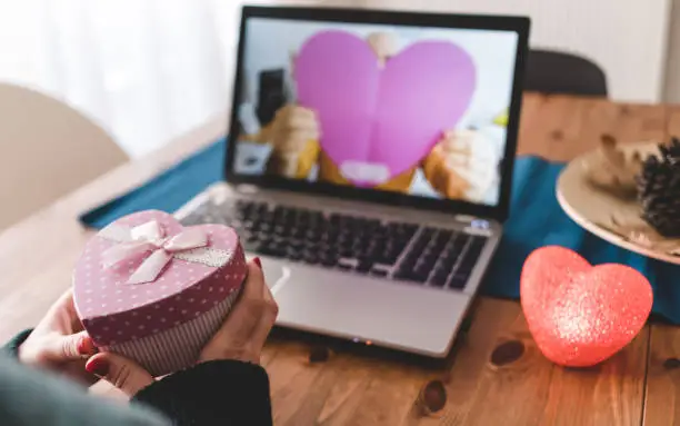 Photo of Couples giving gifts with their girlfriend via video conference.