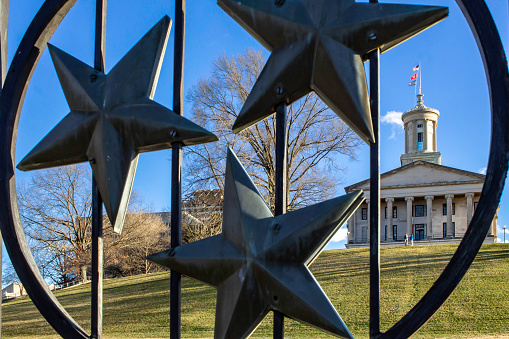 January 18, 2021 - Nashville, Tennessee, U.S.: A fence on the capital grounds with the three stars that represent TN. Behind it on the hill  the Tennessee State Capital building.