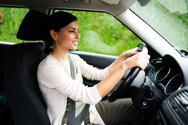 istock Smiling young woman driving 1297310717